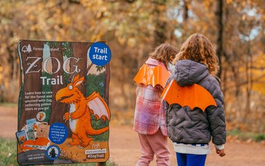 Two children next to Zog trail in a forest