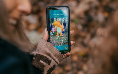 Woman holding phone with Zog app showing