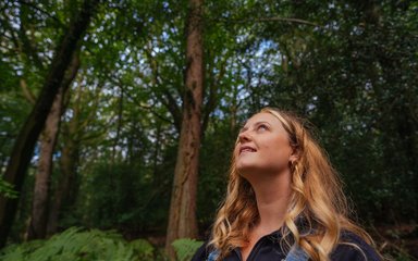 woman looking up into the trees