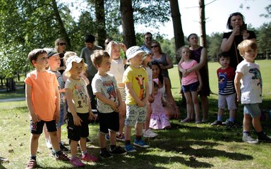 A group of young children in summer clothing are standing together