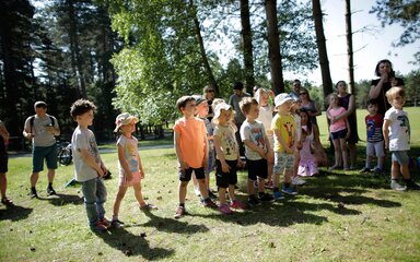 A group of young children in summer clothing are standing together 