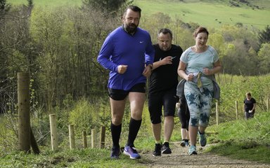 Runners going uphill in the forest 