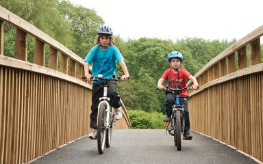 two boys cycling in the forest on a cycle route 