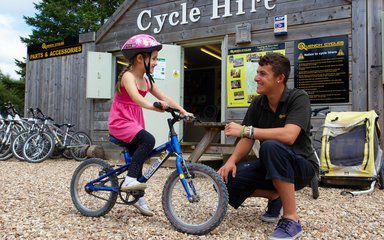 Child outside bike hire shop in the woods