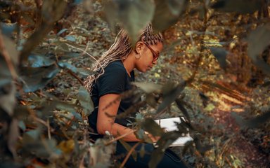 Woman writing on a notepad in the forest