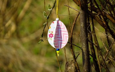 A crafted egg ornament hung from a willow tree