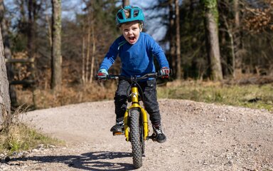 Child riding a mountain bike on a pump track