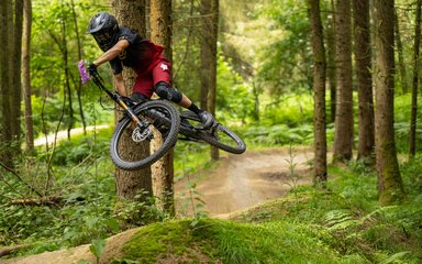 Mountain biker in mid air wearing full face helmet