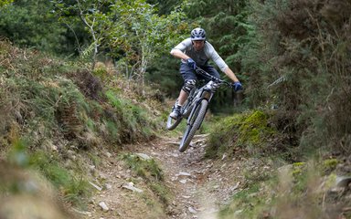 Mountain biker riding a technical trail section