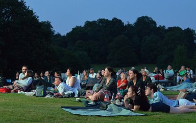 groups of people sit down to enjoy the outdoor cinema screening