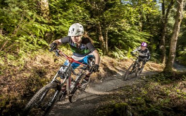 woman on mountain bike trail riding through the forest