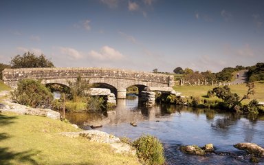 Bridge crossing small river on bright sunny day