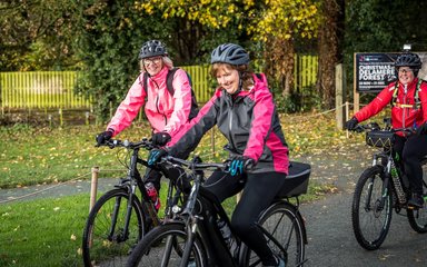 Three women ride bikes 