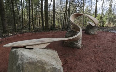 Wooden carved sculpture set on large rocks