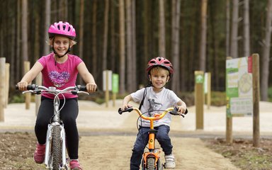 Two small children riding bikes