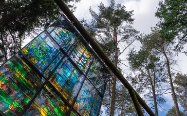 Large stained glass window hanging from the trees