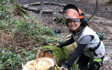 Cheryl Duerden stands next to a felled tree