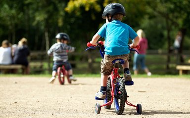 Child on bike cycling into the forest