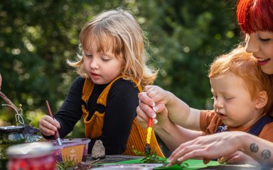 Girl and boy painting in the forest