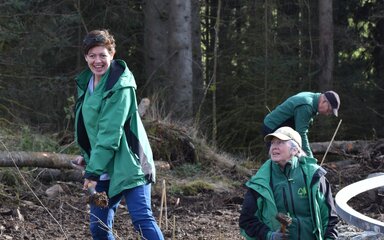 A woman digging in the forest.