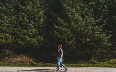 A couple on a forest road in a conifer forest