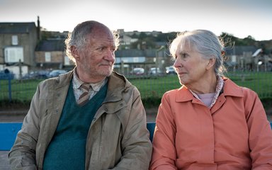 Harold and Maureen sat on a bench looking at each other