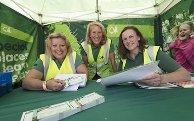 Three women sat behind ticket bench at Forest Live concert
