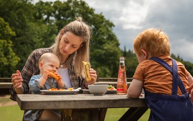 Mother and baby having lunch at picnic table