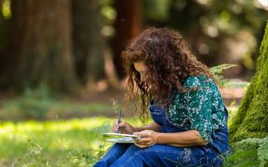 Woman writing in the forest