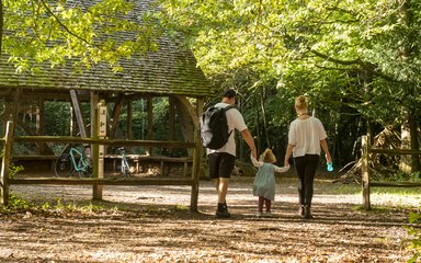 Family walking past a wooden structure