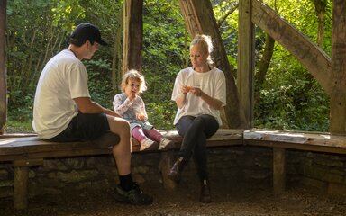 A family enjoying a snack break in a wooden shelter