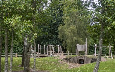 An assortment of wooden play features within a forest