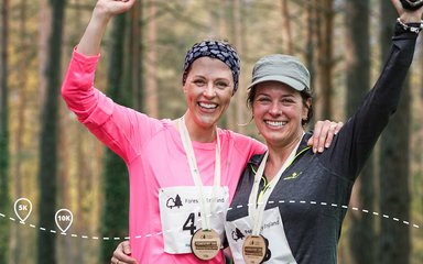 Two women smiling with race medals