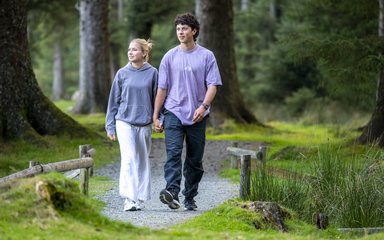 A couple walking along a surfaced forest trail