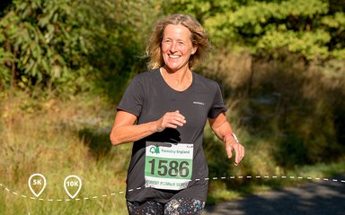 Happy woman running an event through forest