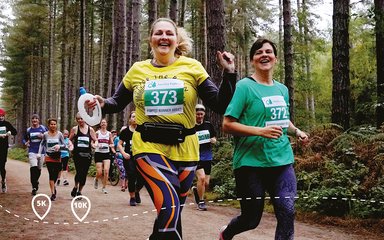 Happy women running in an event through the forest