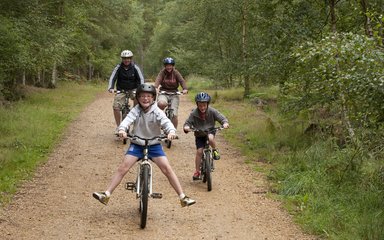 Family on bike ride along forest trail