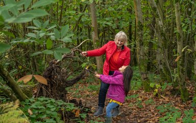 Grandma and granddaughter playing together in the forest 