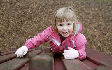 Little girl climbing in play area