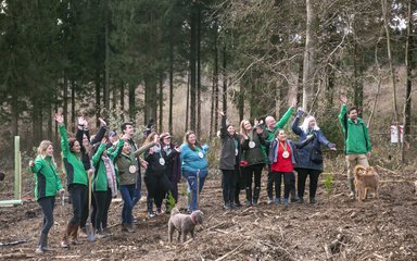 Group of people waving happily in a forest