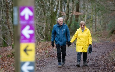 couple walking in the forest on waymarked trail