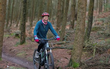 Woman riding a bike through Haldon Forest