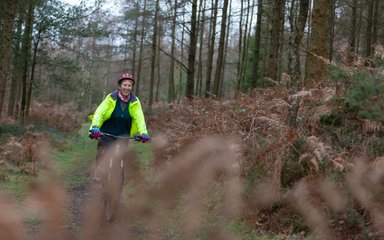 lady beginner mountain biker cycling in woods