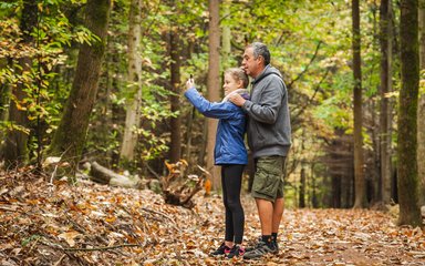 Family taking pictures in forest