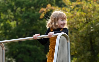 child playing on play equipment 