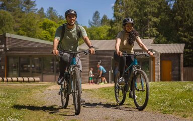 Two cyclists in front of the Activity Centre at Alice Holt Forest