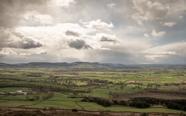 A view of open arable land with a range of hills on the skyline.