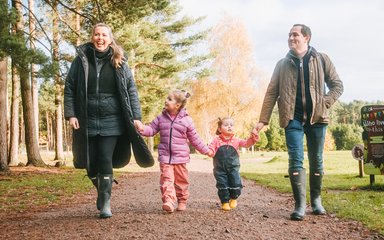 Man, woman and two children walking along an autumnal forest trail