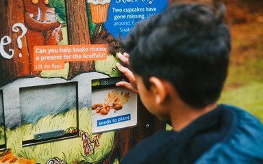 boy interacting with a Gruffalo activity panel
