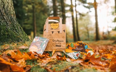paper party bag and stickers on a forest floor